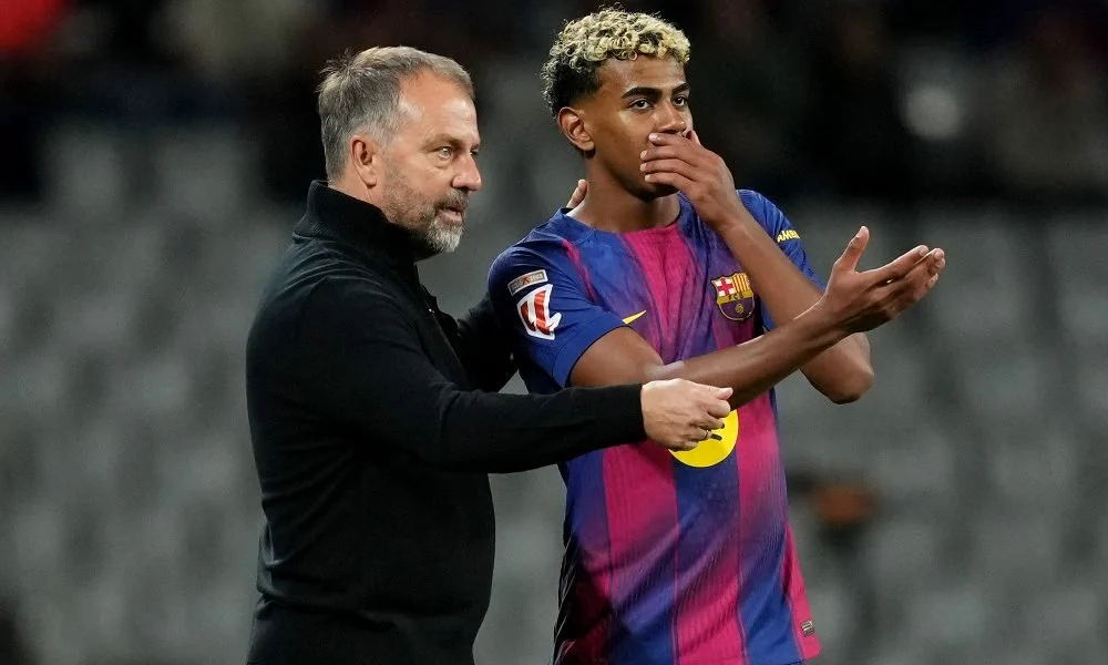 Hansi Flick, Head Coach of FC Barcelona, speaks with Lamine Yamal