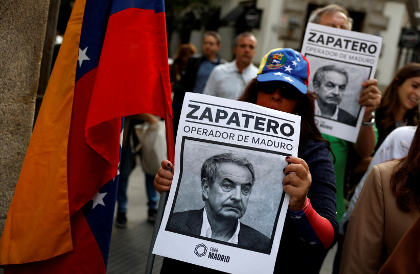 Supporters of Venezuelan opposition presidential candidate Edmundo Gonzalez hold signs against Spain's former Prime Minister Jose Luis Rodriguez Zapatero that read ''Zapatero, Maduro’s handler'', outside the venue where Zapatero attends a book presentation in Madrid, Spain, September 24, 2024.