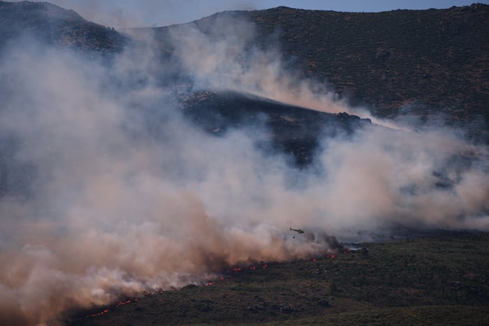 Tens of thousands of people flee raging wildfires in France and Spain, some escaping by boat