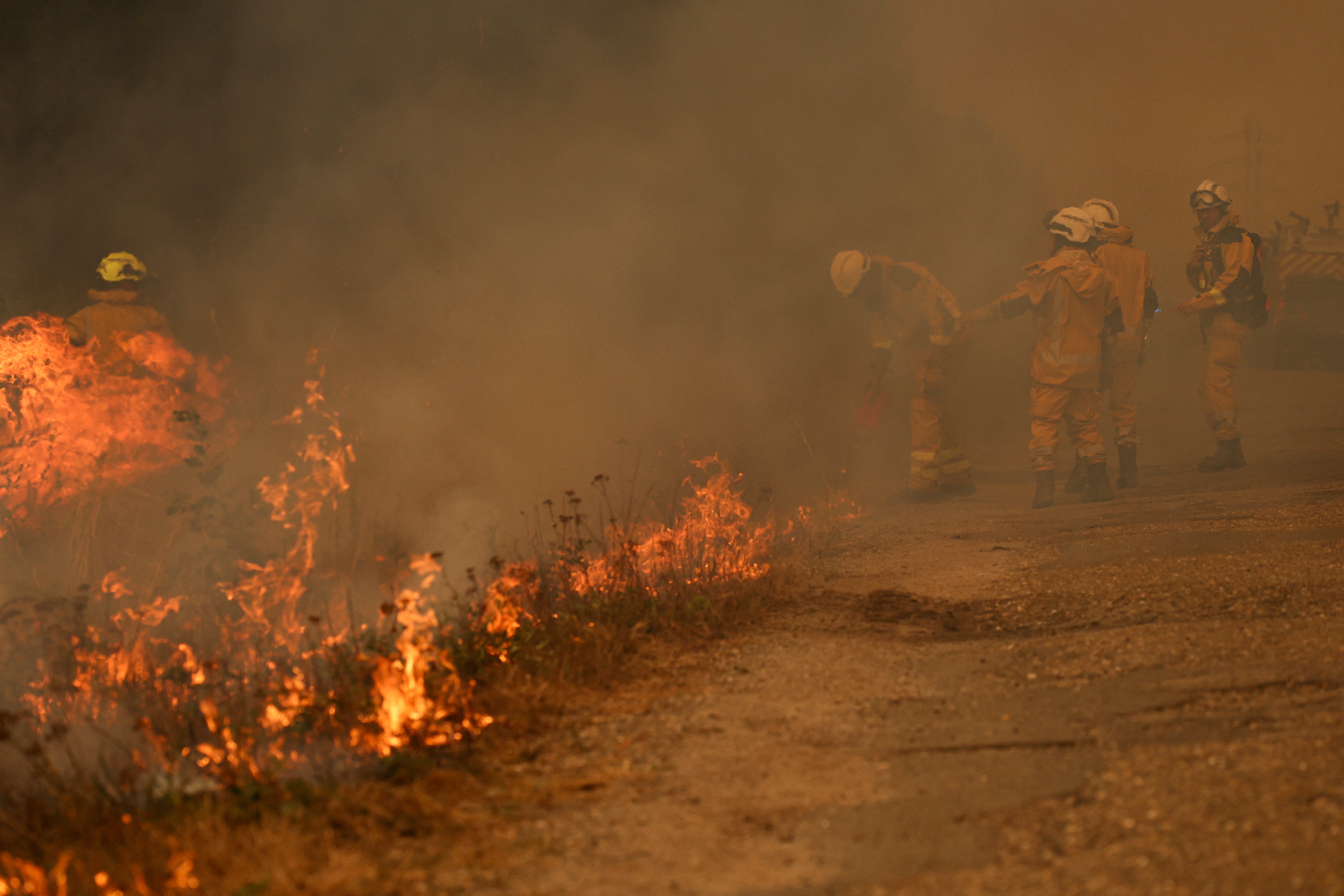 Firefighters burn vegetation to create a fuel-free buffer zone as they fight a huge wildfire in Marcheprime, west of Bordeaux