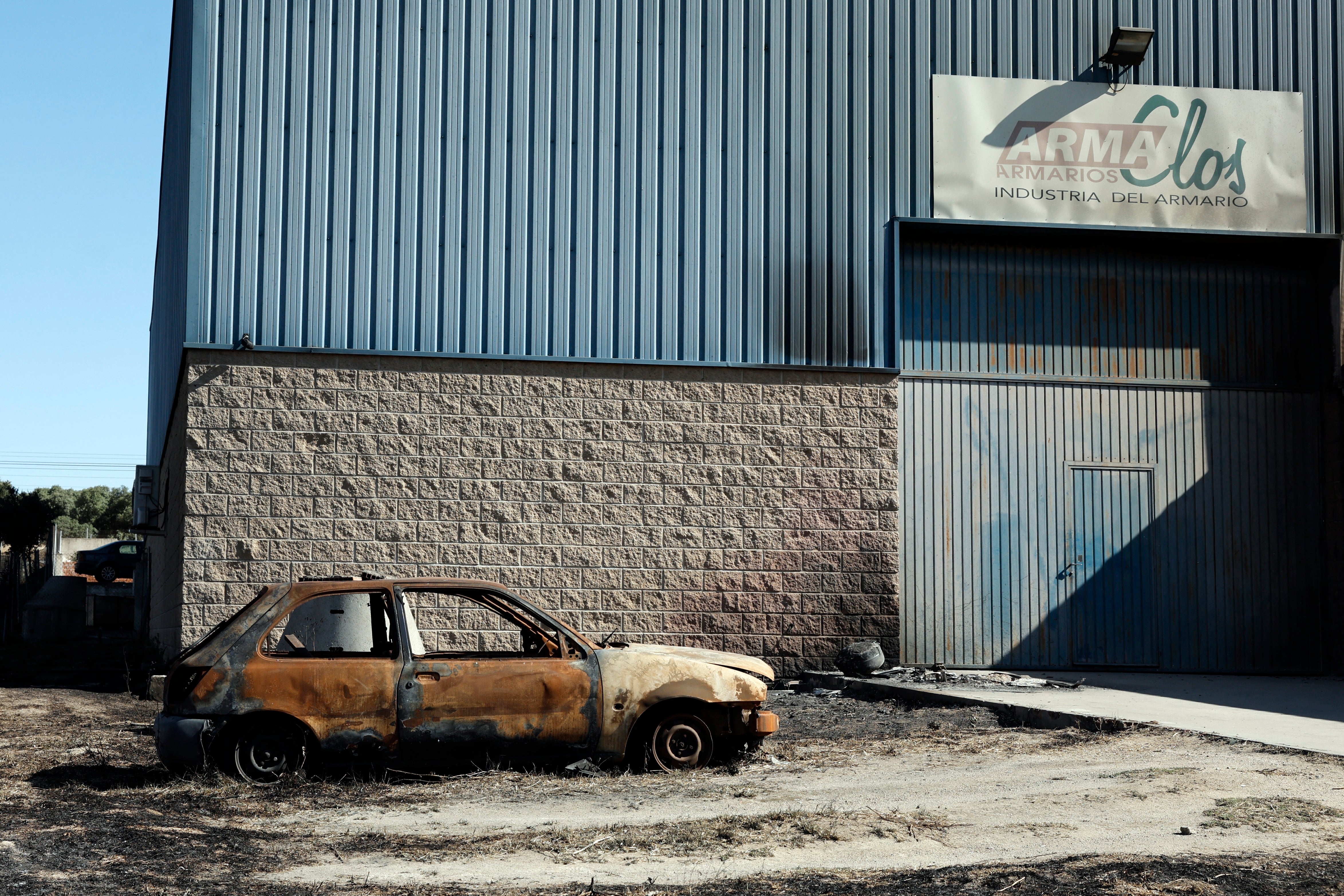 A burnt-out vehicle is seen following a wildfire in Chapineria, 50km west of Madrid