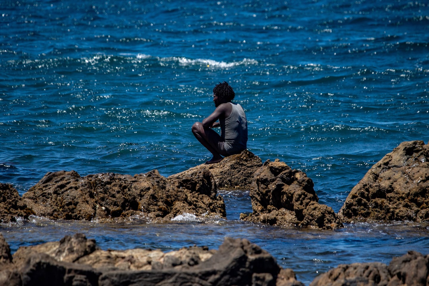 A migrant who crossed into Spain from Morocco sat on the shore in the Spanish enclave of Ceuta on Aug. 2.