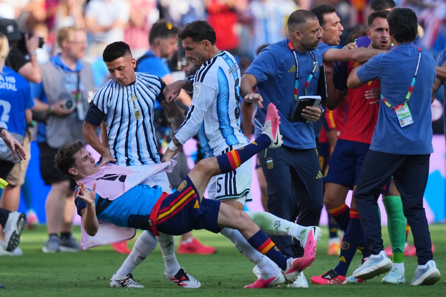 Argentina's Leandro Paredes (5) knocked down Spain's Gavi (9) as Argentina coaches (right) scuffled with Spain's Eric García (4) after the World Cup final.