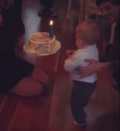 Briana and Louis Tomlinson celebrating Freddie's first birthday with a cake.
