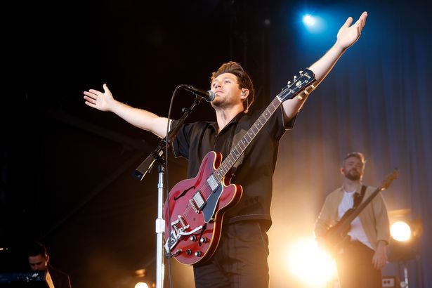 Niall Horan arms out on stage