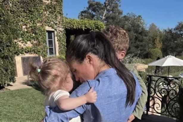 Meghan Markle holding her children Archie and Lilibet on each hip