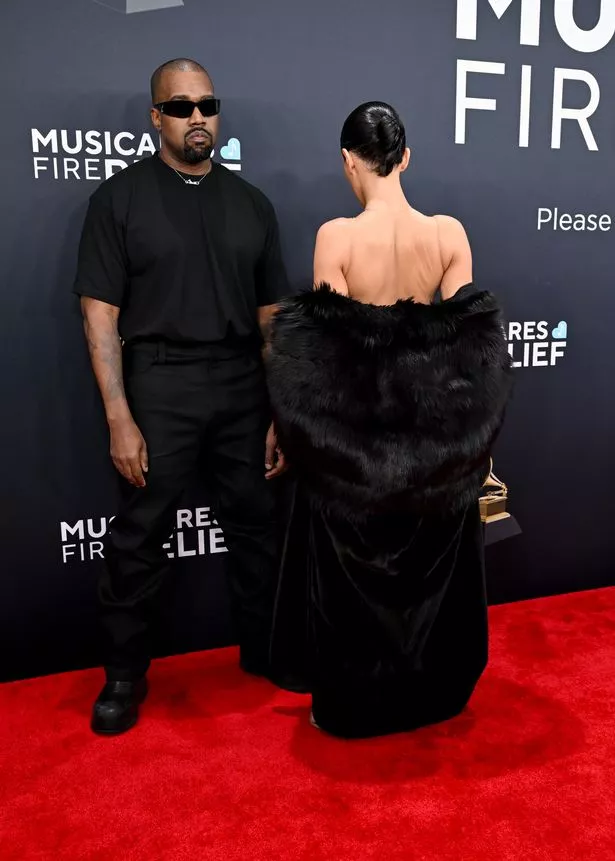 Kanye West and Bianca Censori who is facing the wall show off her nude upper back.