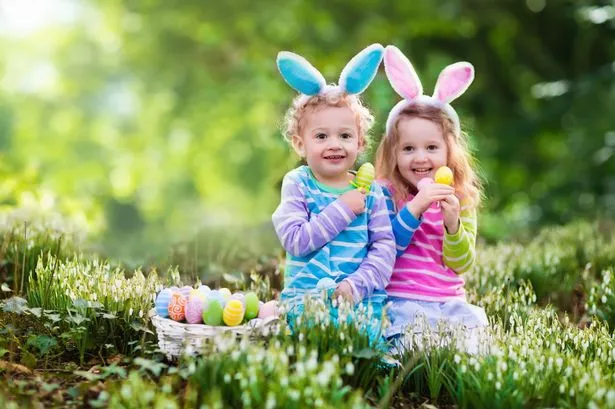 Children on Easter egg hunt wearing bunny ears