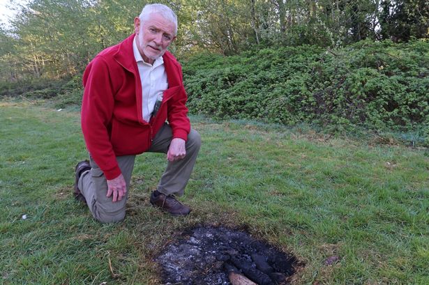 Cllr Dave Antrobus next to a piece of scorched grass in Otterspool Park
