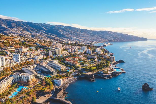 Aeral view of blue clear skies, seaside, mountains and buildings