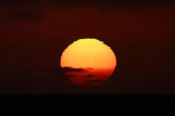 The sun sets on the horizon