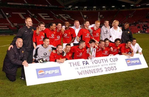Manchester United's players celebrate on the pitch with the FA Youth Cup on the Old Trafford pitch.