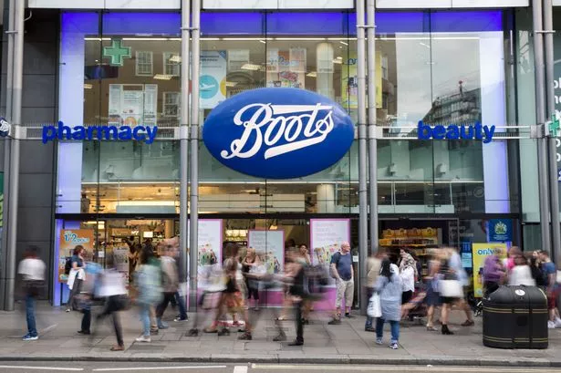  Members of the public walk past a branch of Boots the chemist on Oxford Street 