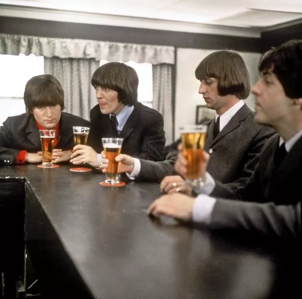 Rock and roll band 'The Beatles' drink a beer in a still from their movie 'Help!' which was released in 1965