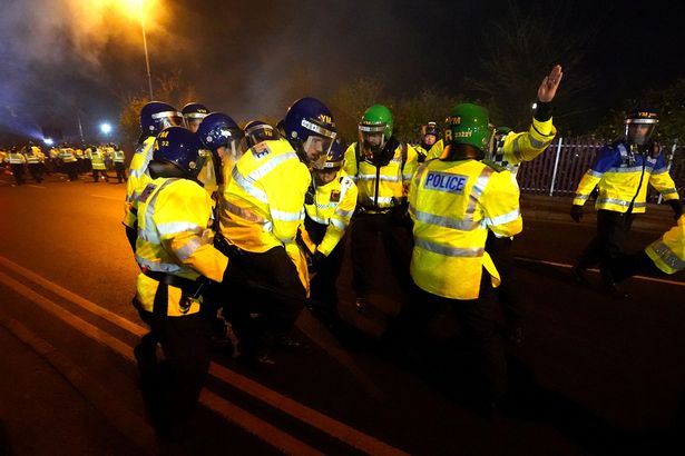 A police officer is helped up by their colleagues after being hit by a flare outside Villa Park before the UEFA Europa Conference League Group E match between Aston Villa and Legia Warsaw 