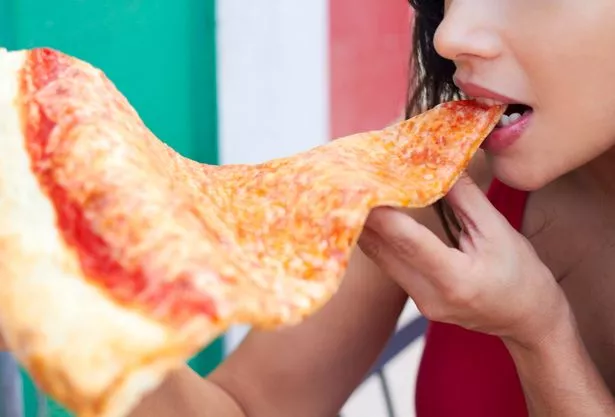 woman Eating Large Slice Of Pizza