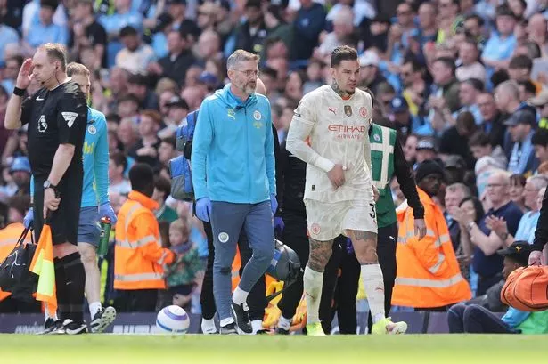 Manchester City goalkeeper Ederson leaves the pitch after going down injured