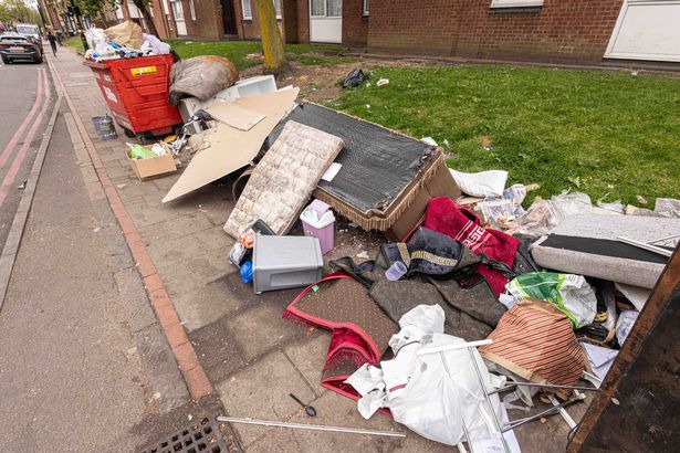 Rubbish left at the side of Stratford Rd, Sparkhill, Birmingham, during the bin strike, including a large communal bin full of rubbish a sofa and other household items 