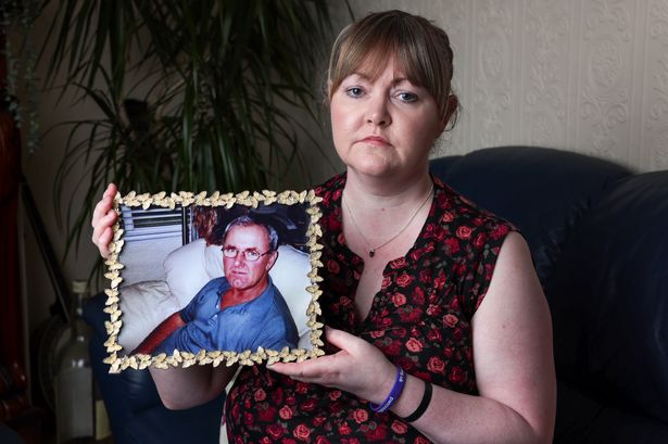 Claire McHarron holding a picture of her dad Henry, who was murdered 18 years ago