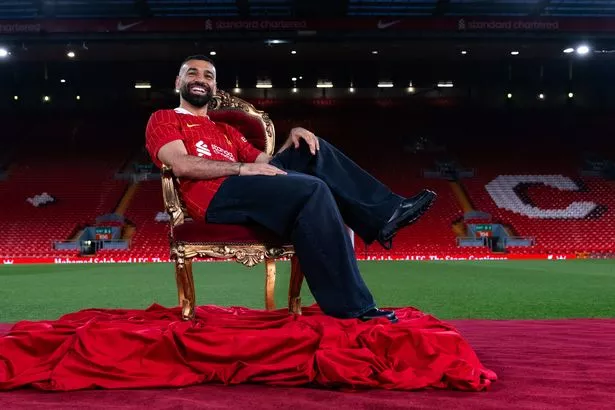 Mohamed Salah of Liverpool poses for photos as he signs a new contract extension at Anfield on April 10, 2025 in Liverpool, England