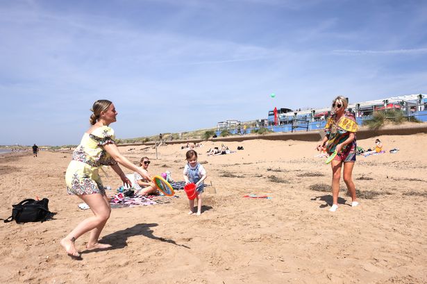 People enjoy the hot weather on Crosby beach this afternoon
