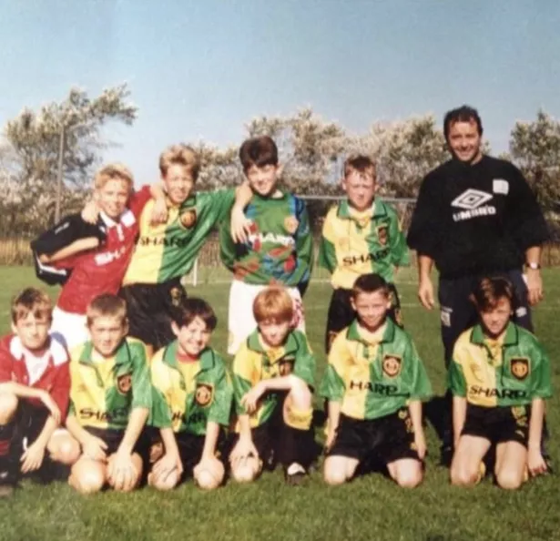 Lee Lawrence stands alongside some of his former peers for a team photo, each wearing Manchester United kits.