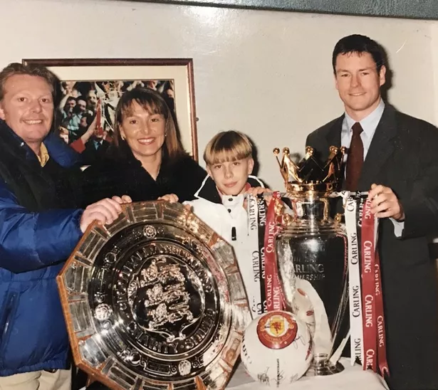 Lee Lawrence stands alongside his parents and former Manchester United coach Paul McGuinness.