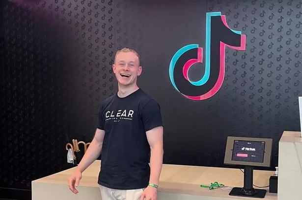 Man stands in front of desk