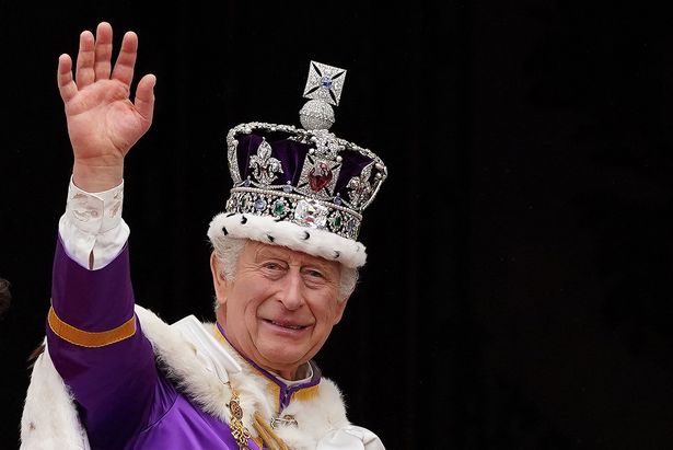 Britain's King Charles III wearing the Imperial state Crown, waves from the Buckingham Palace balcony after viewing the Royal Air Force fly-past in central London on May 6, 2023