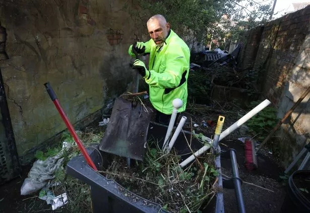 The Sefton Council fly-tipping clearing team clean out an entry in Bootle