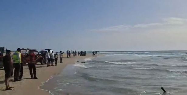 A photo of people standing by the shore near where the attack happened 