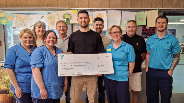 Scott Gold hands over the donation to staff at the NRU.