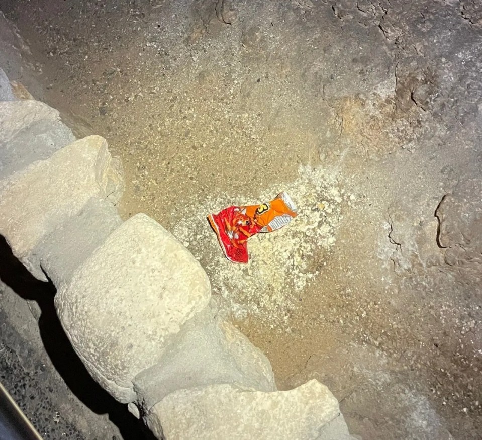 a piece of bread is laying on the ground in a cave