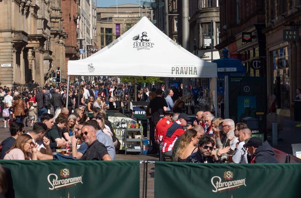 Fans enjoying sunshine at an outdoor beer garden in Glasgow.