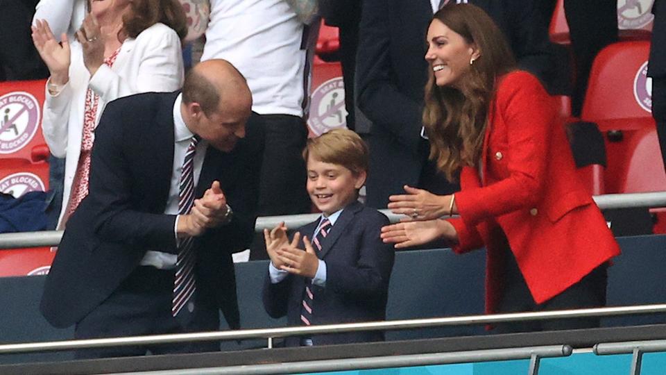 Prince William, Prince George and Kate Middleton applauding together.