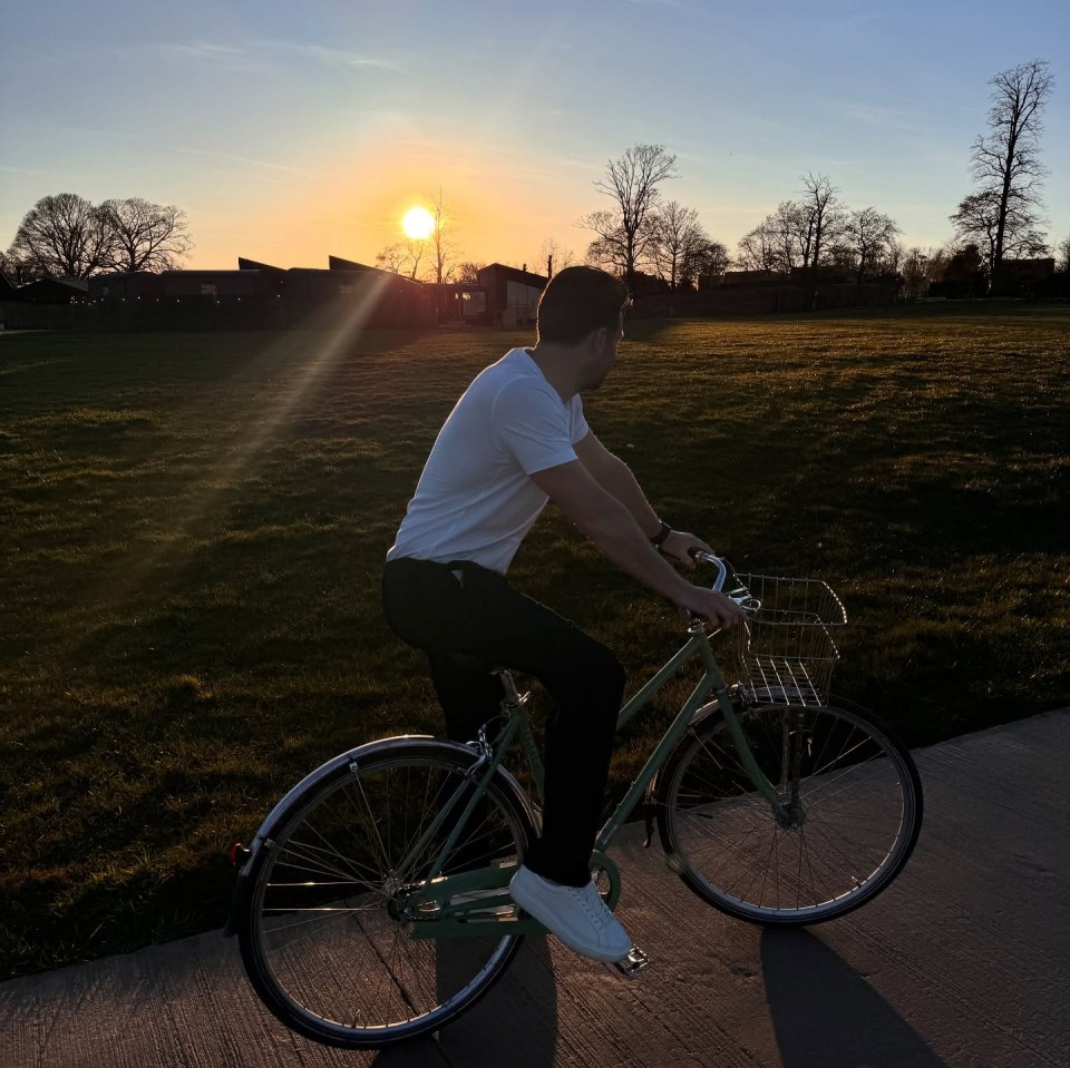Man riding a bicycle at sunset.
