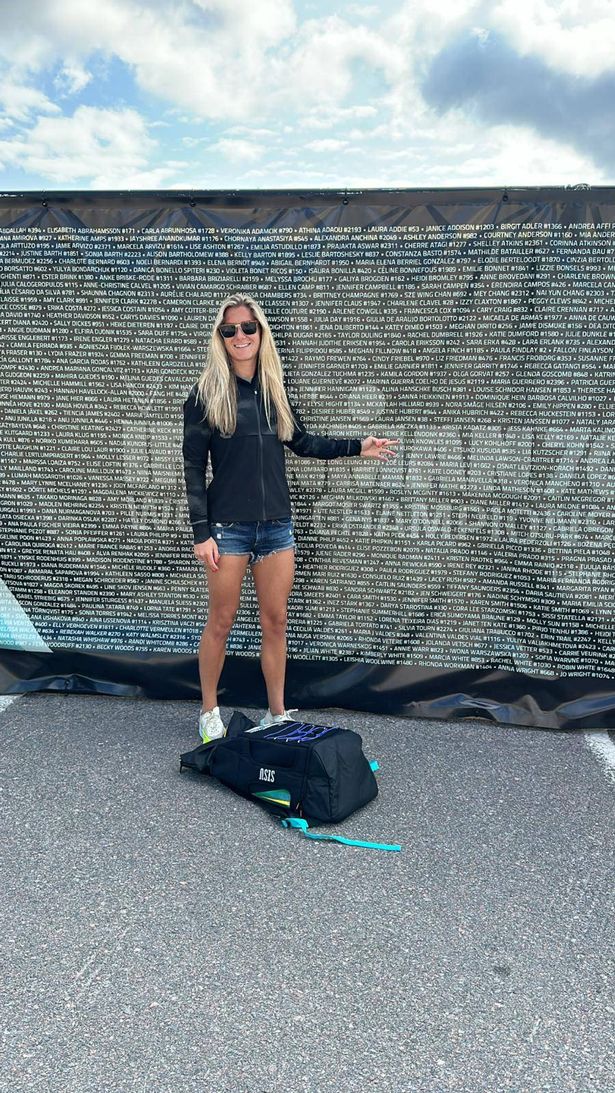 Olivia in front of a sign reading "Ironman 70.3 World Championship"