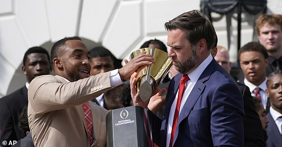 TreVeyon Henderson holds the top of the trophy as Vice President JD Vance holds the base that had come apart as President Donald Trump welcomes the 2025 College Football National Champions, the Ohio State University football team, on the South Lawn of the White House, Monday, April 14, 2025, in Washington. (AP Photo/Alex Brandon)