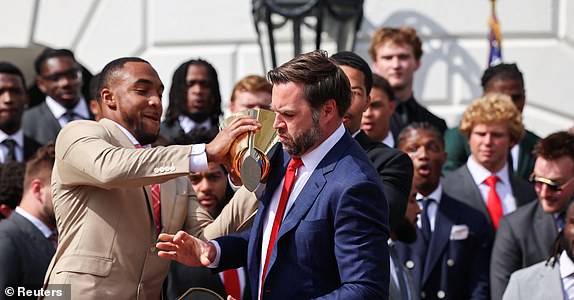U.S. Vice President JD Vance drops the trophy, as he and President Donald Trump (not pictured) meet the Ohio State University 2025 College Football National Champions, at the White House, in Washington, D.C., U.S., April 14, 2025. REUTERS/Evelyn Hockstein