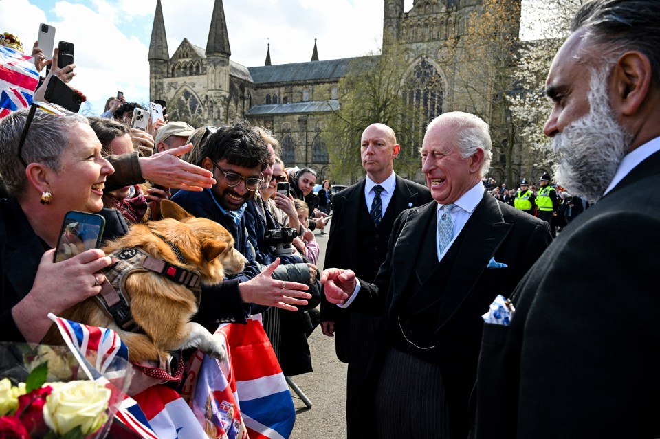 King Charles III greeting well-wishers and a dog after a Royal Maundy Service.