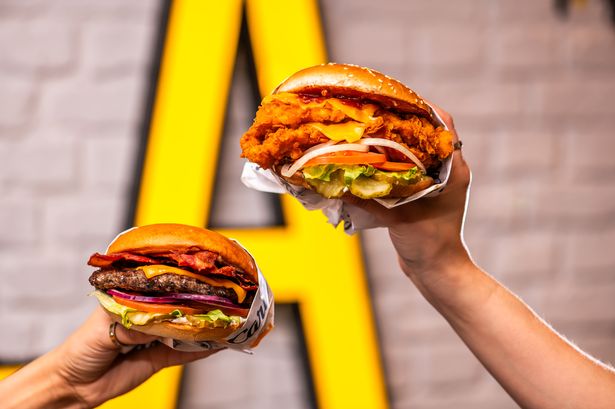 image of two burgers being held up 