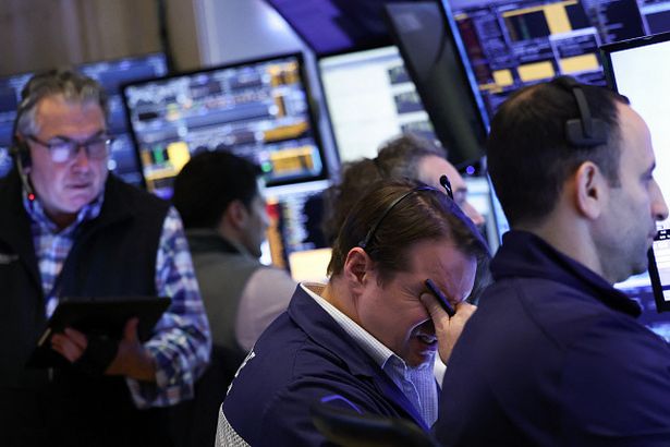 Traders work on the floor of the New York Stock Exchange (NYSE) at the opening bell in New York City