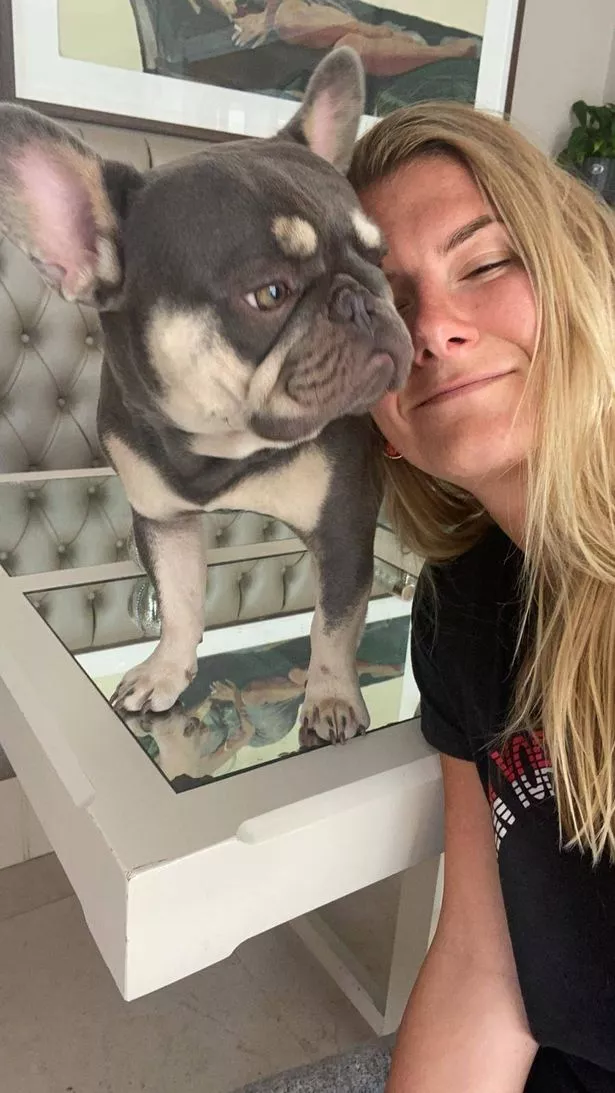 Olivia with long hair next to her grey and white french bulldog