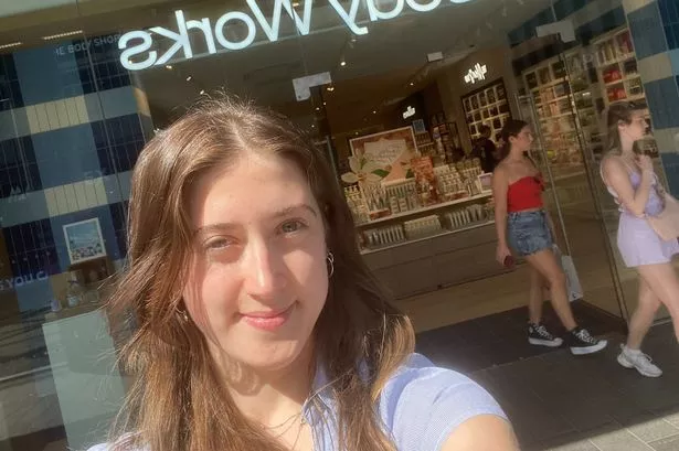 This photo shows a woman taking a selfie outside a Bath & Bodyworks