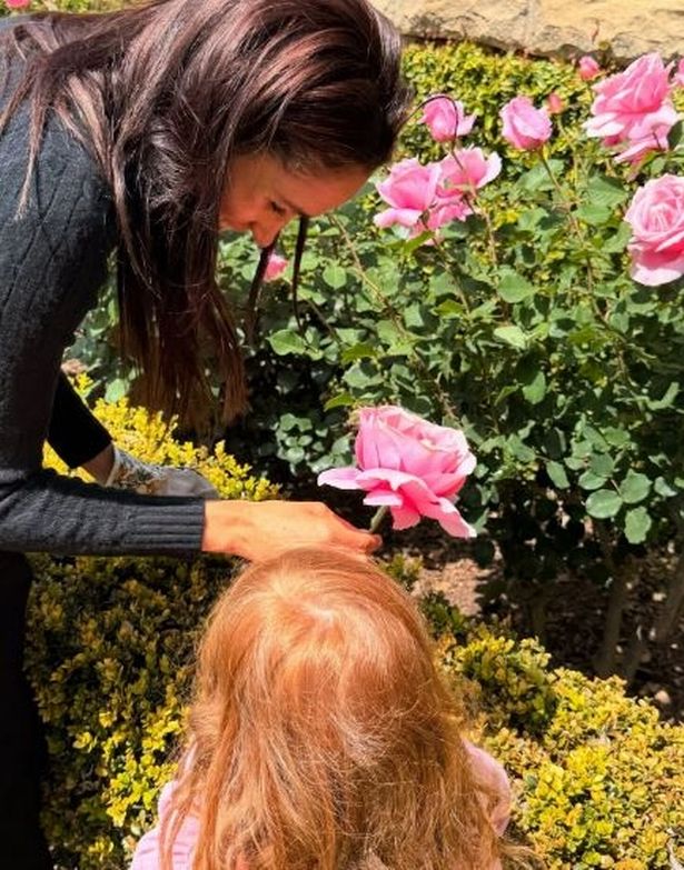 Meghan Markle with her daughter Lilibet picking flowers in the garden