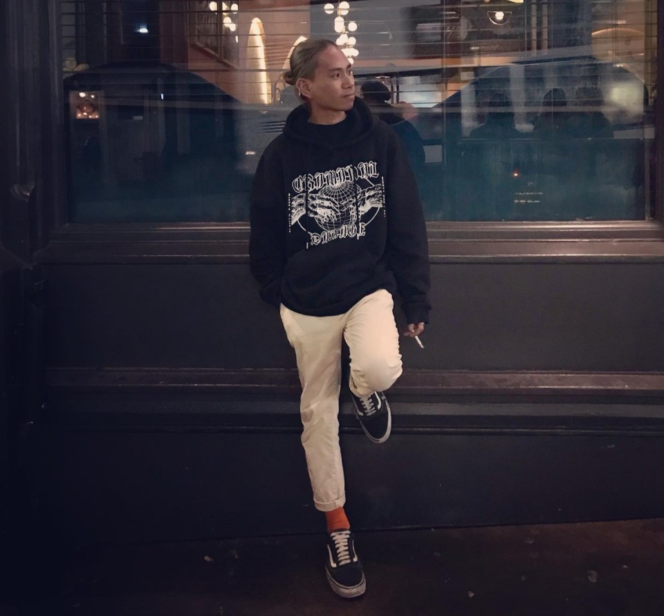 A person standing outside, smoking a cigarette.