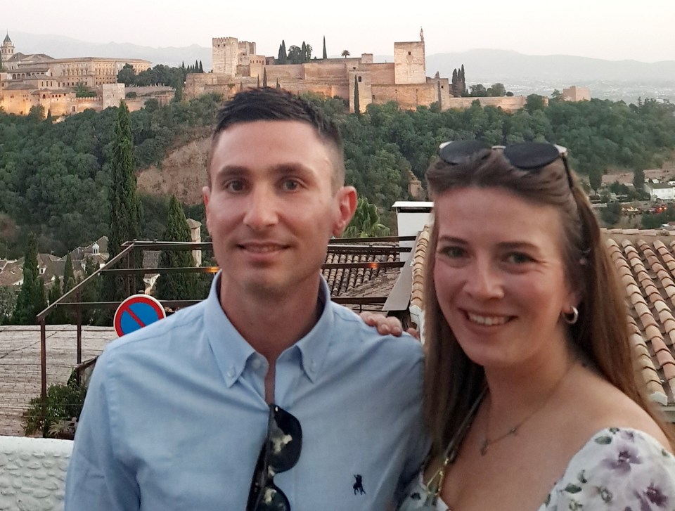 Couple posing for a photo with Alhambra in the background.