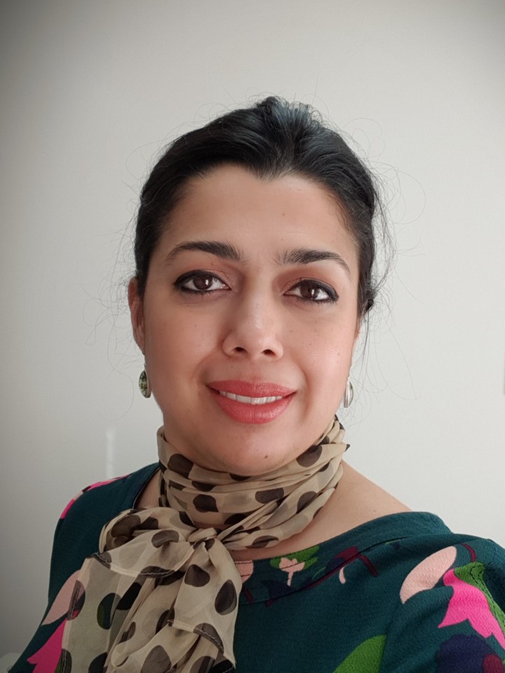 Headshot of a woman wearing a polka dot scarf.