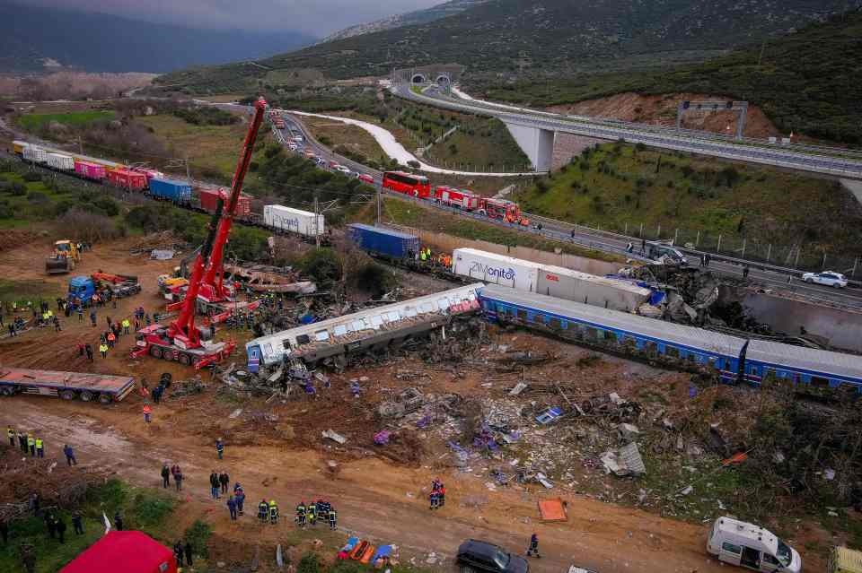 Aerial view of a train accident scene with emergency crews and wreckage.
