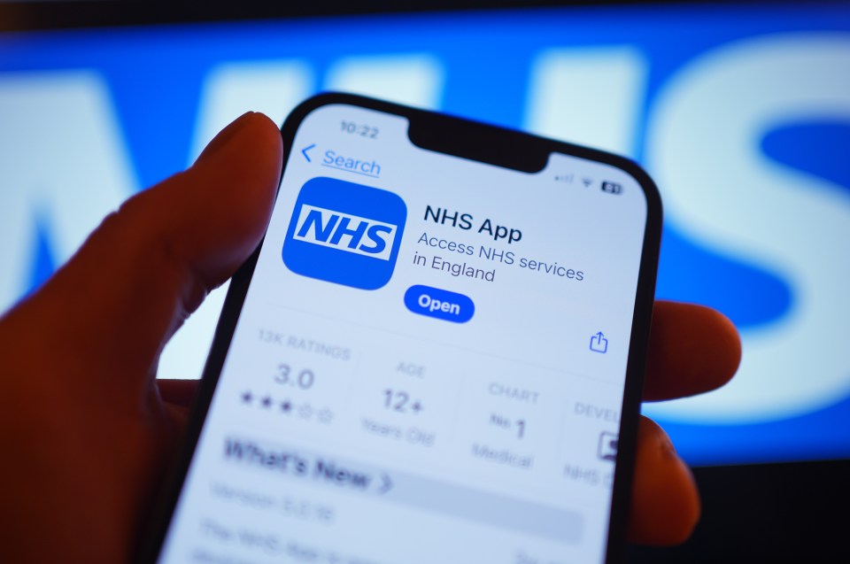 Close-up of a hand holding a smartphone displaying the NHS app.